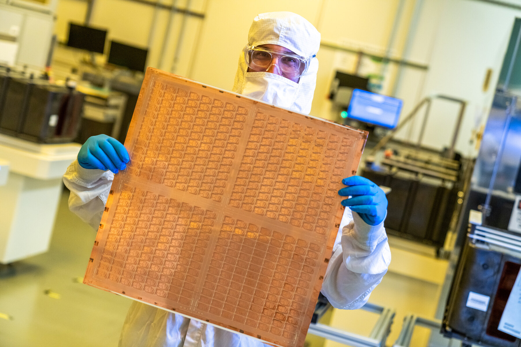A technician in an Intel cleanroom holds a real advanced glass-substrate panel